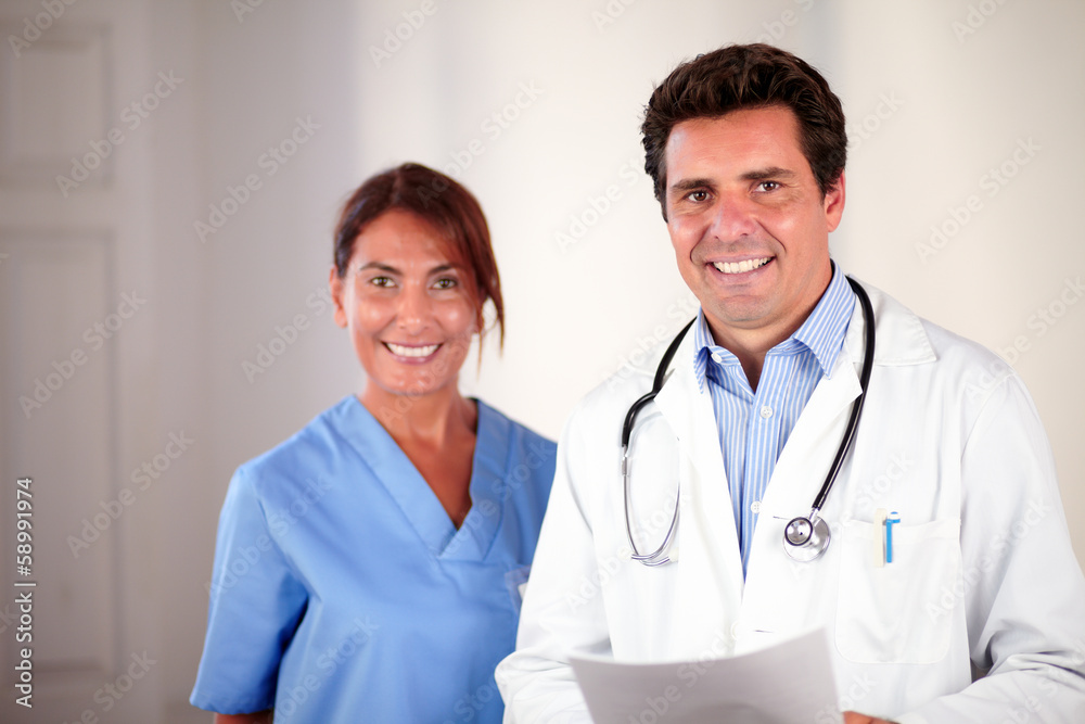 Hispanic doctor couple looking and smiling at you Hispanic doctor couple looking and smiling at you