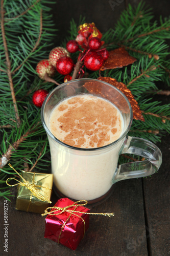 Cup of eggnog with fir branches and Christmas decorations