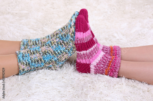 Legs in colorful socks on white carpet background