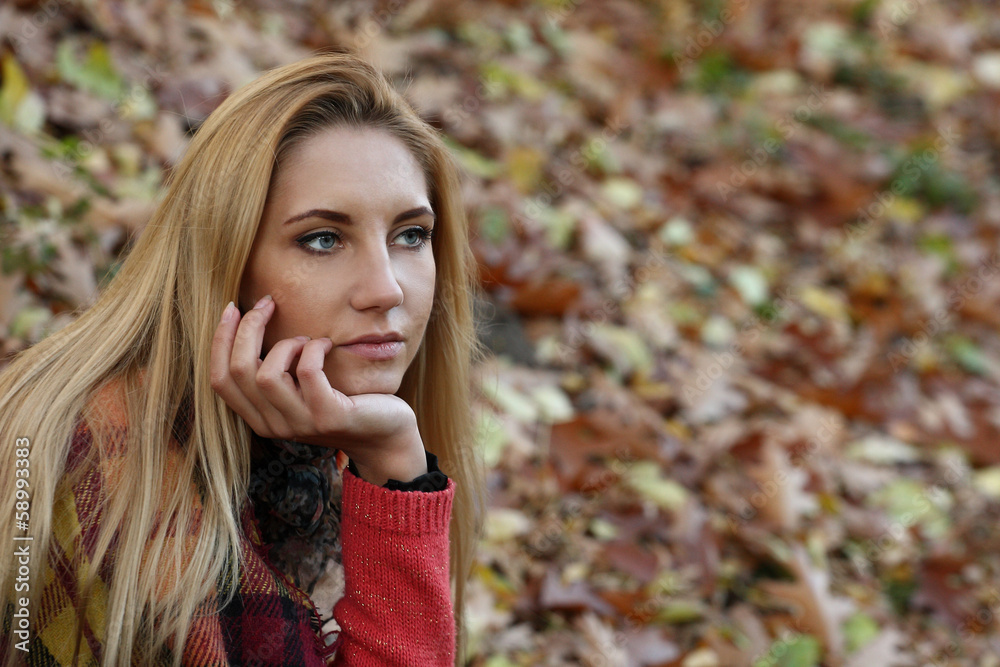Naklejka premium Beautiful young blond woman in autumn park