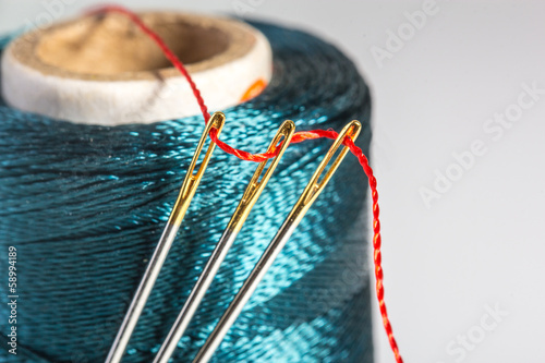Macro green spool of thread with needle