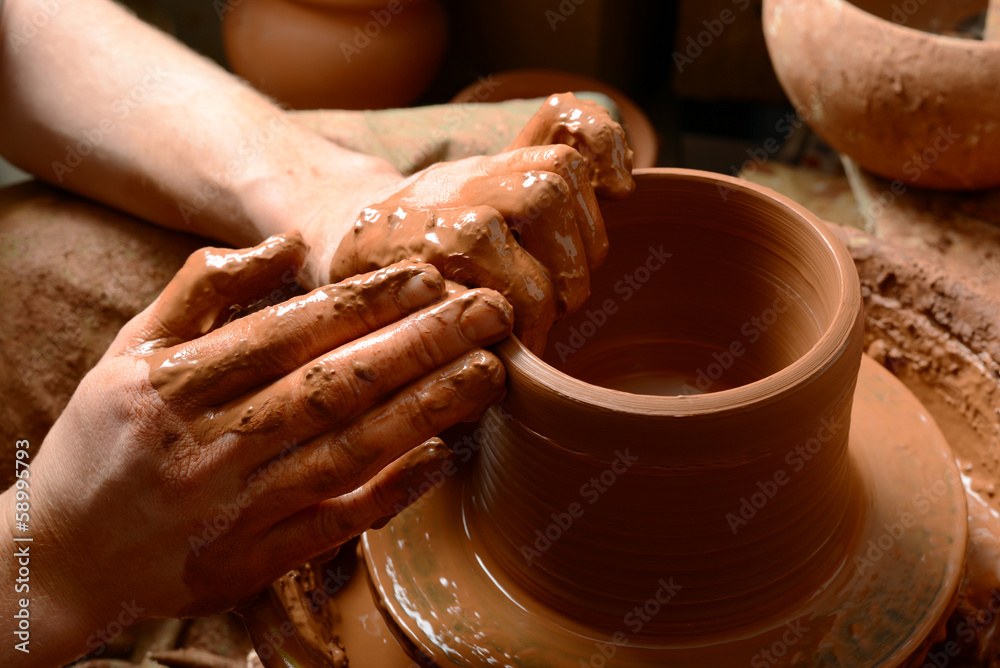 hands of a potter, creating an earthen jar on the circle