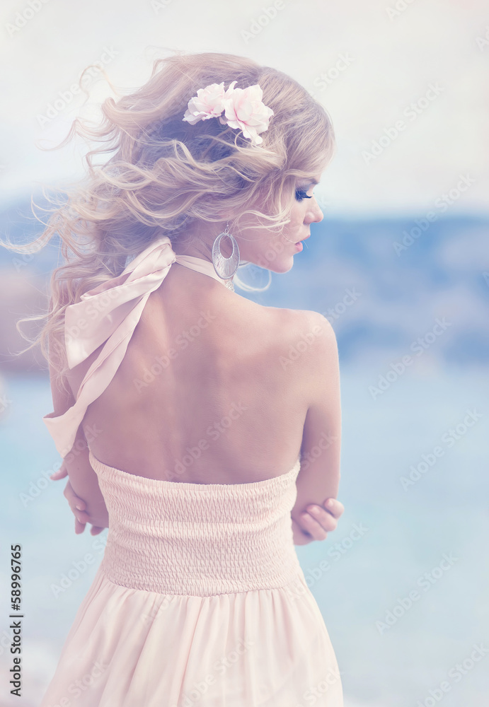 Gorgeous blonde in white dress on the beach