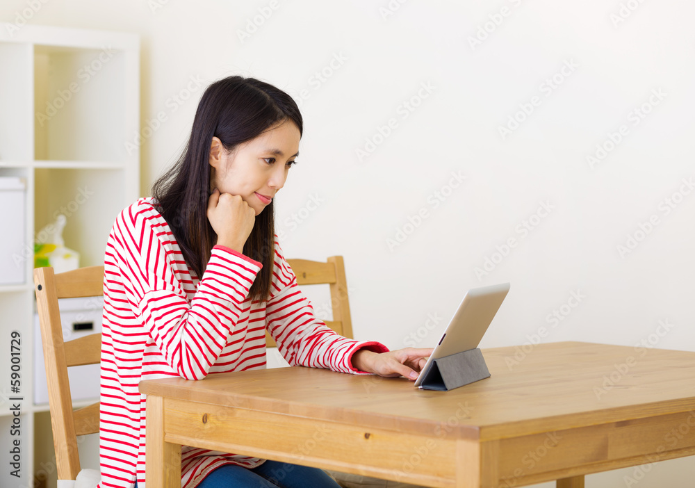 Asian woman using digital tablet at home