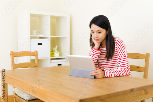 Asian woman using tablet computer at home © leungchopan