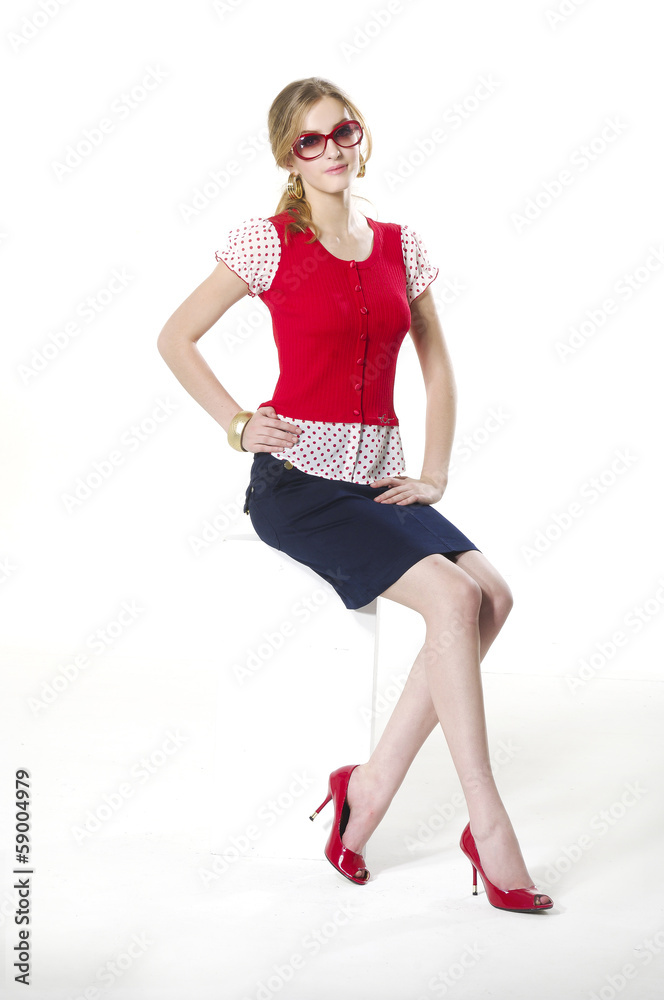 Fototapeta premium Portrait of young woman in sunglasses sitting cube