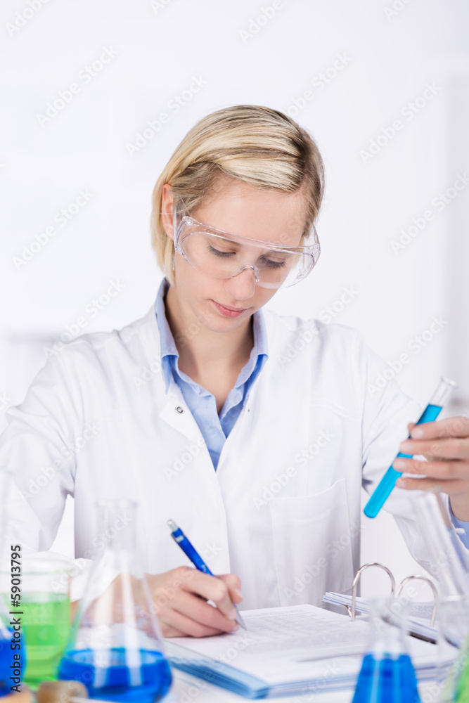 laborantin notiert ergebnisse in ihren unterlagen laborantin notiert ergebnisse in ihren unterlagen