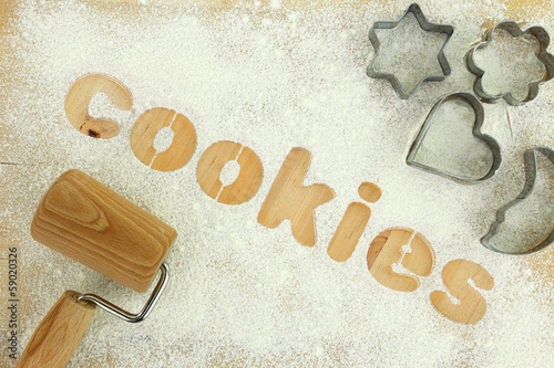 Stencil word "cookies" made with flour on wooden table