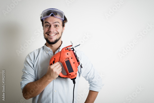 young man bricolage working with electric saw photo