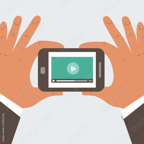 Mobile phone with video player on the screen in the human hands
