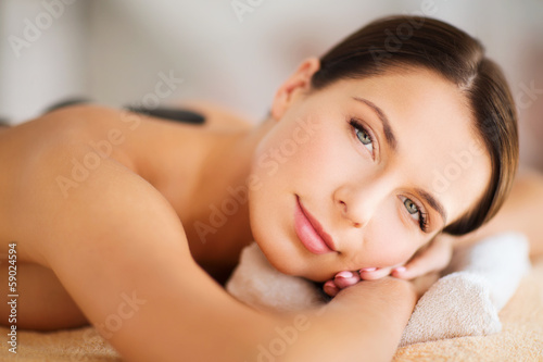 beautiful woman in spa salon with hot stones