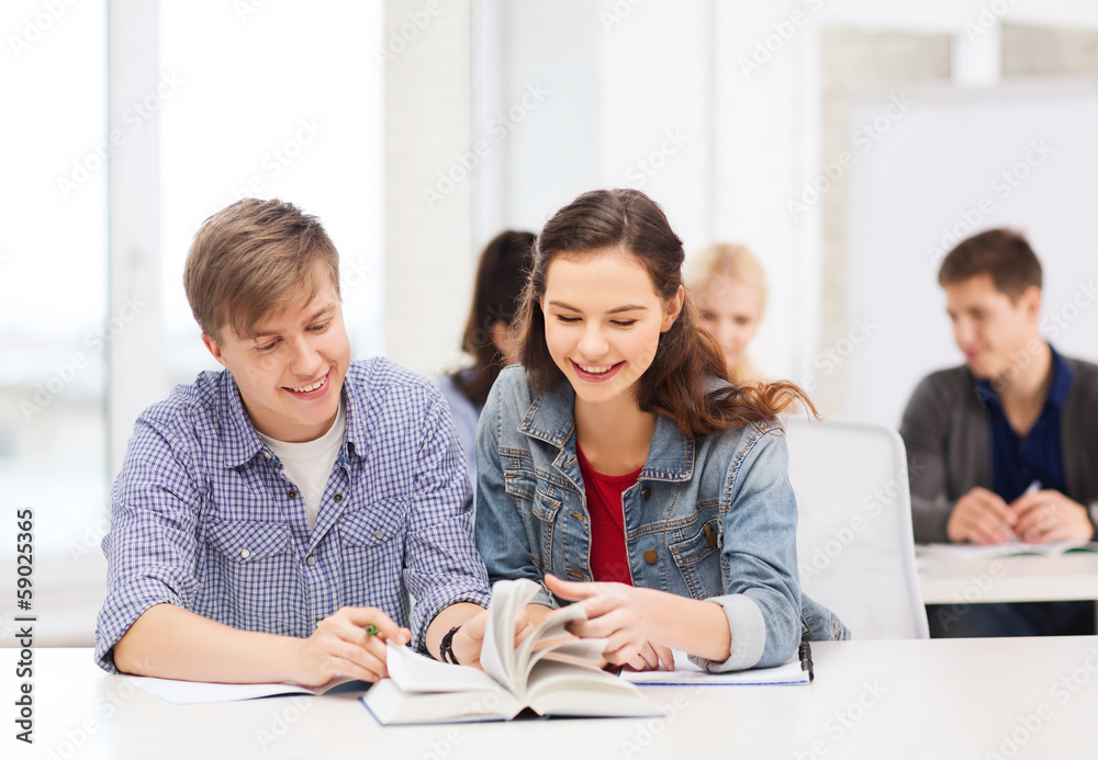 Fototapeta premium two teenagers with notebooks and book at school