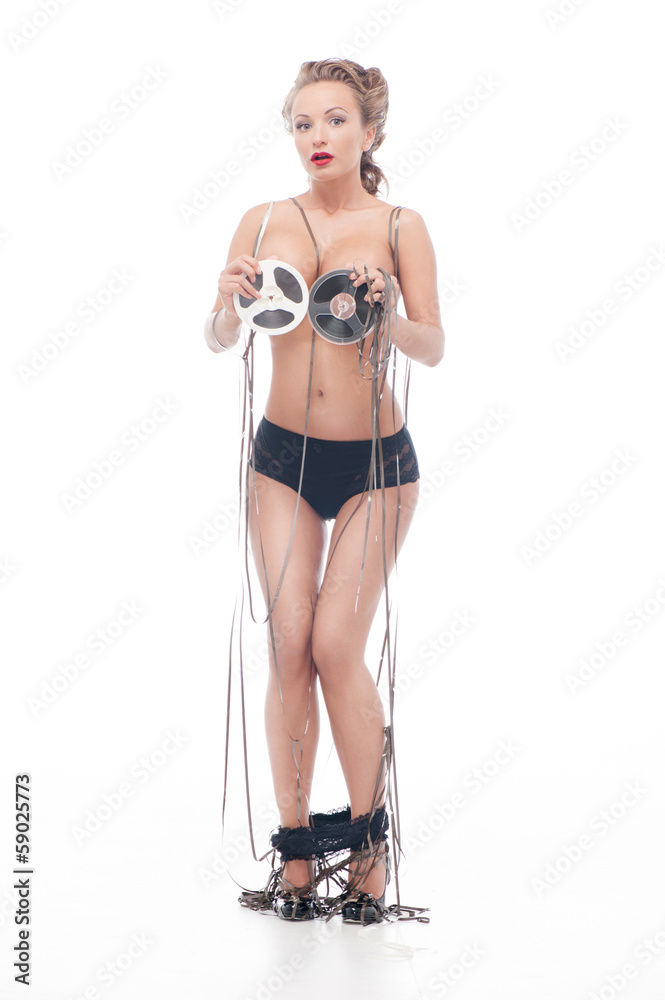 Fototapeta premium Attractive nude woman covered up with an audio retro bobbins