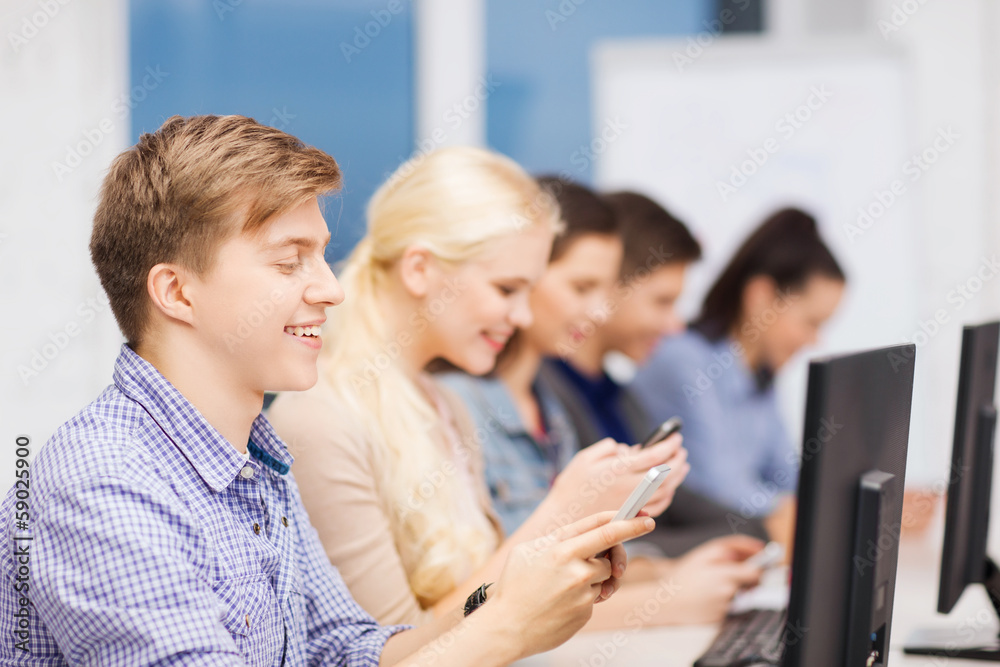 students with computer monitor and smartphones students with computer monitor and smartphones