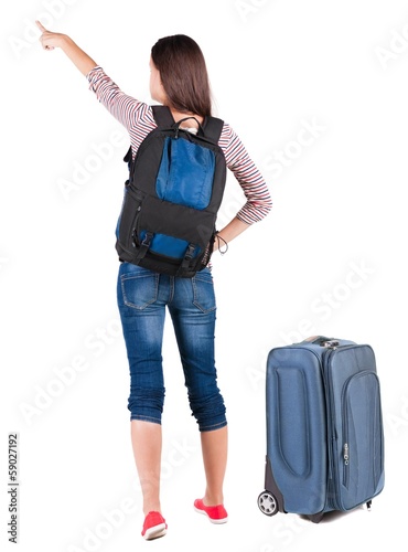 Back view of pointing woman with backpack looking up.