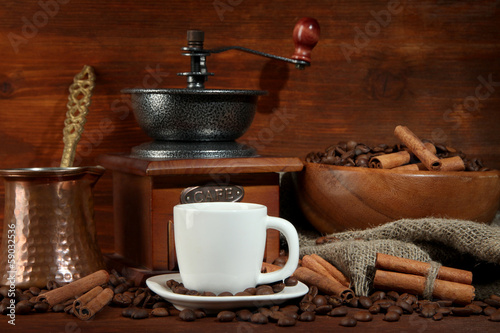 Coffee cup and metal turk on wooden background