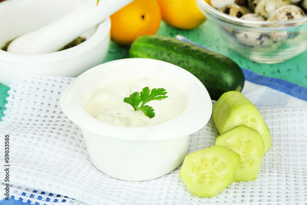 Cucumber yogurt in bowl, on color napkin, on wooden background Cucumber yogurt in bowl, on color napkin, on wooden background