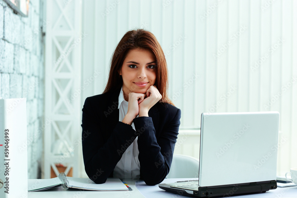 Young cheerful businesswoman sitting at the table Young cheerful businesswoman sitting at the table
