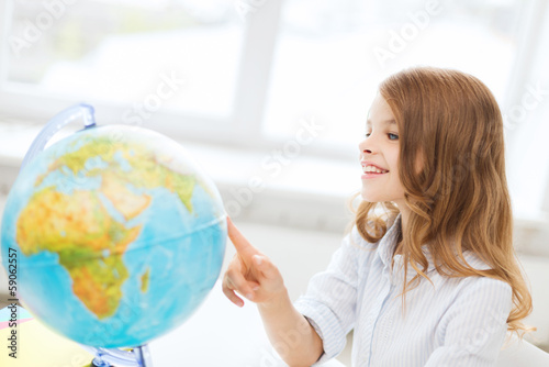 smiling student girl with globe at school