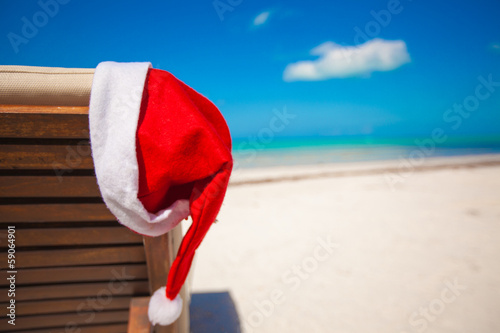 Fototapeta Naklejka Na Ścianę i Meble -  Close-up of santa hat on chair longue at tropical caribbean