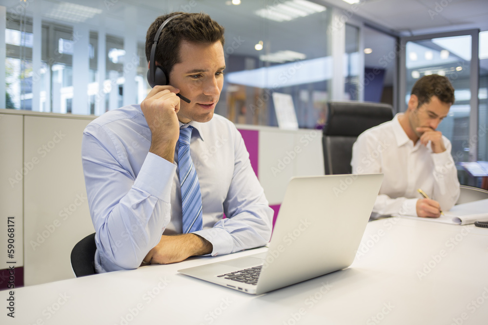 Businessman in the office on the phone with headset, Skype Businessman in the office on the phone with headset, Skype