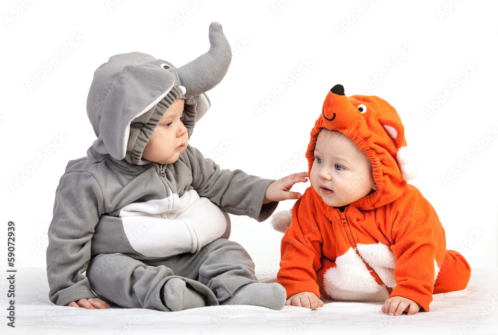 Two baby boys dressed in animal costumes playing over white Two baby boys dressed in animal costumes playing over white