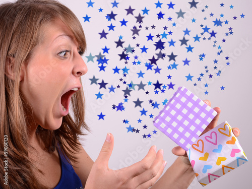 junge frau beim öffnen von geschenk photo