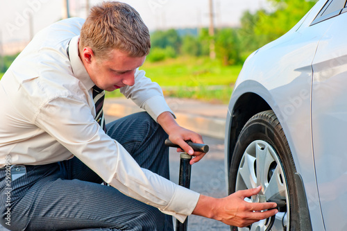 businessman pumps car tire pump photo