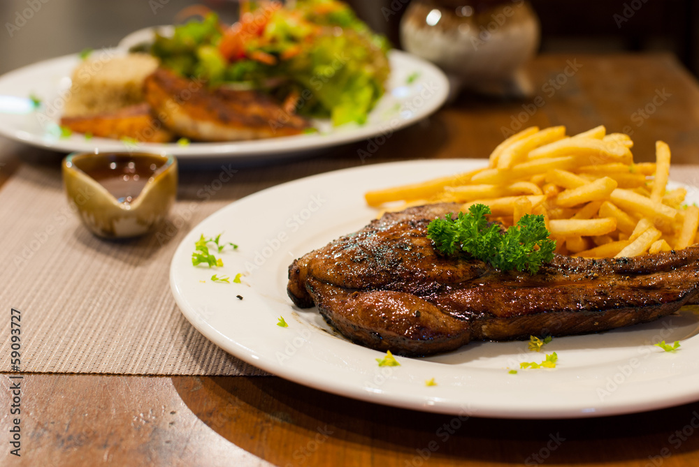 Pork Chop Grilled steak with French Fries, top with parsley. Pork Chop Grilled steak with French Fries, top with parsley.