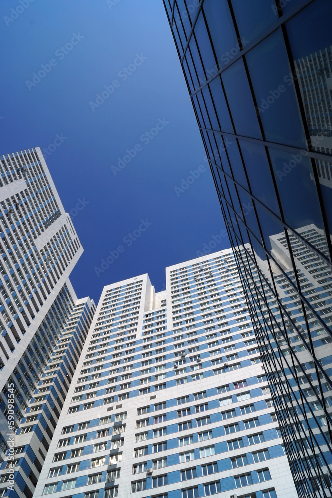 high-rise building reflection in a mirror facade of office build high-rise building reflection in a mirror facade of office build