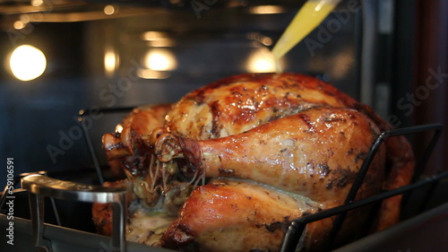 Basting a Seasoned Whole Turkey with Melted Butter