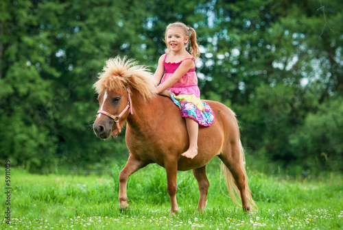 Little girl riding little pony