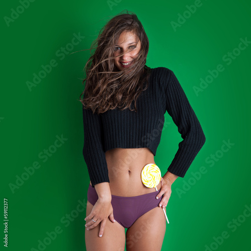 Canvas Print Portrait of young beautiful woman with lollipop on green backgro