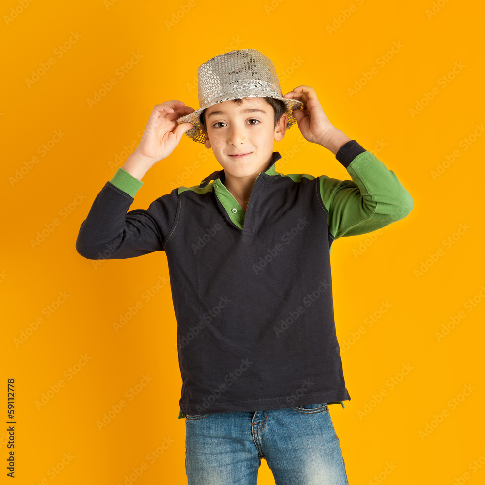 Young kid portrait with hat against orange background.