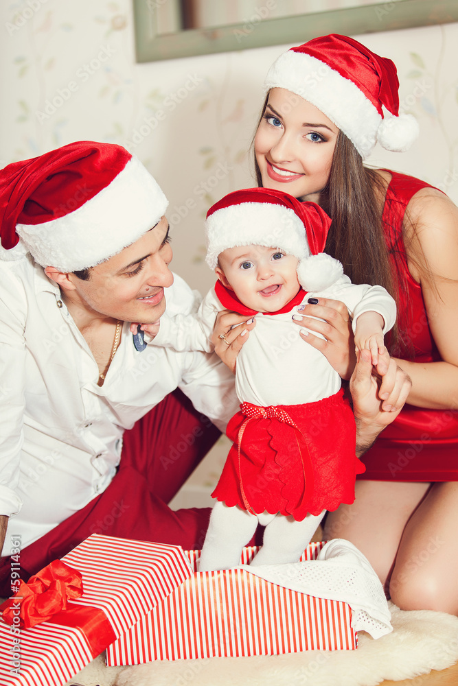 Fototapeta premium Happy family with cute baby in suit of Santa's little helper