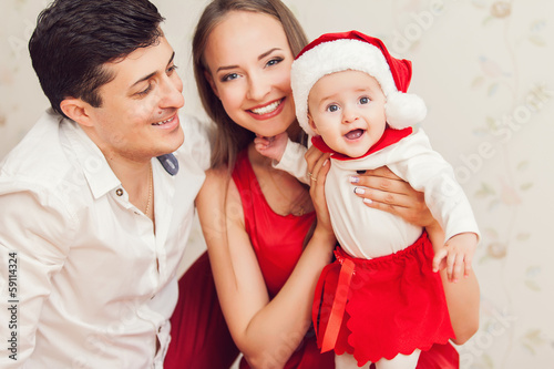 Happy family with cute baby in suit of Santa's little helper