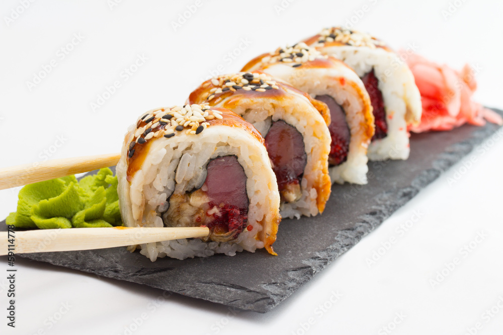 Sushi roll on stone plate isolated on white background Sushi roll on stone plate isolated on white background