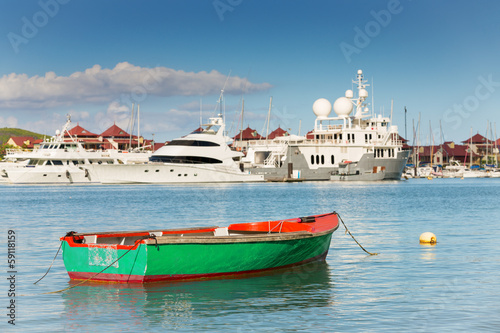 Fishing boat with luxurious yachts background, Eden Island, Mah