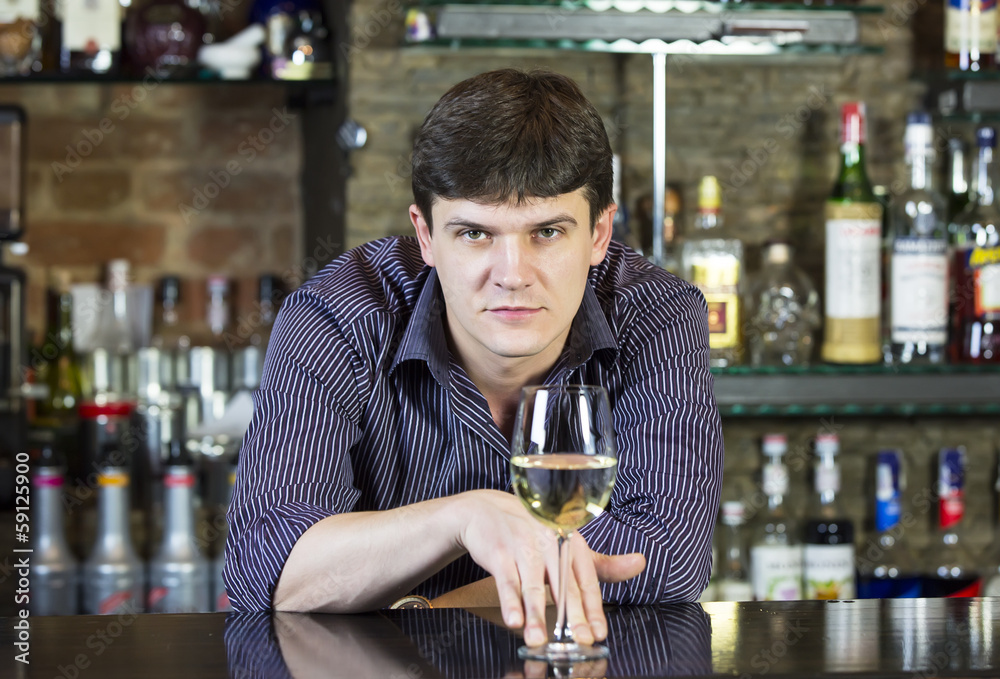 young man working as a bartender in a nightclub bar young man working as a bartender in a nightclub bar
