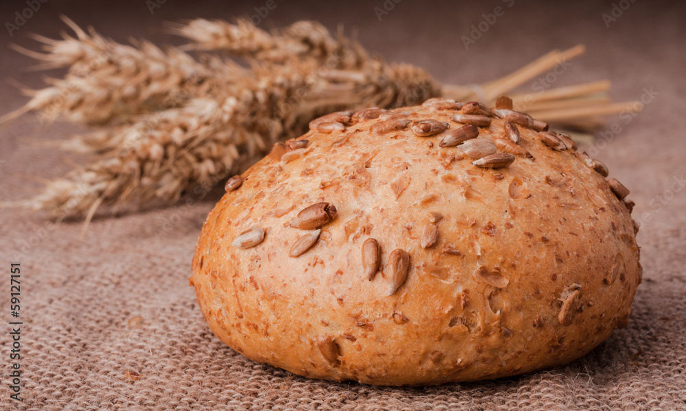 Loaf of bread and wheat ears still life
