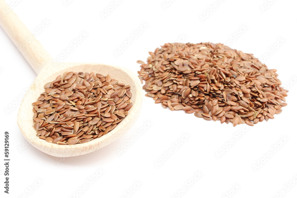 Heap of linseed with wooden spoon on white background Heap of linseed with wooden spoon on white background