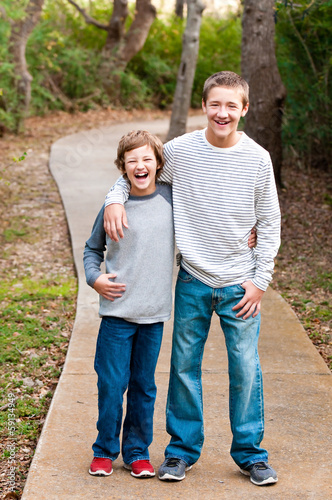 Teen brothers laughing, outdoors