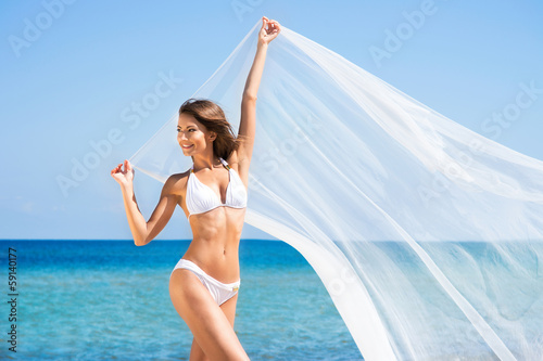 A beautiful woman in a swimsuit posing on the beach