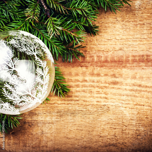 Christmas Tree Branch on wooden background with festive glass b