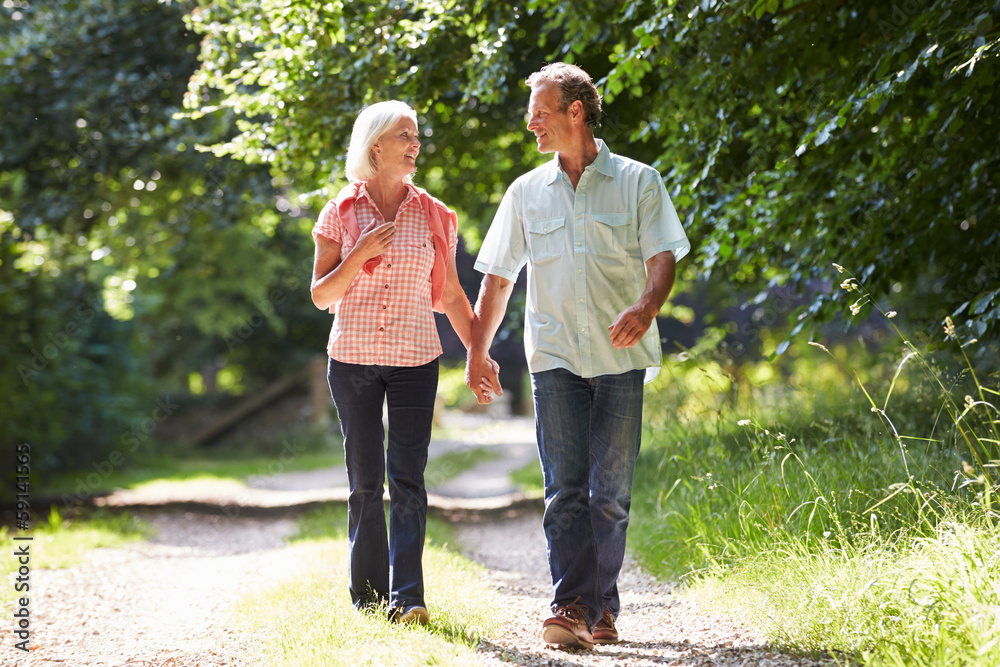 Romantic Middle Aged Couple Walking Along Countryside Path - obrazy, fototapety, plakaty 