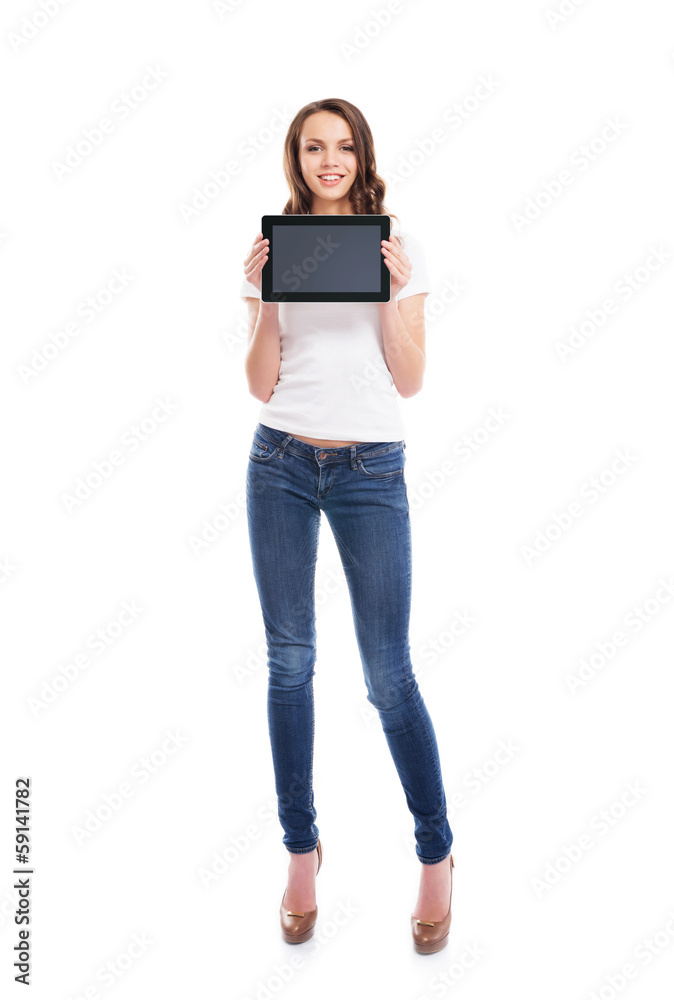 A young and happy girl in stylish jeans holding a tablet A young and happy girl in stylish jeans holding a tablet