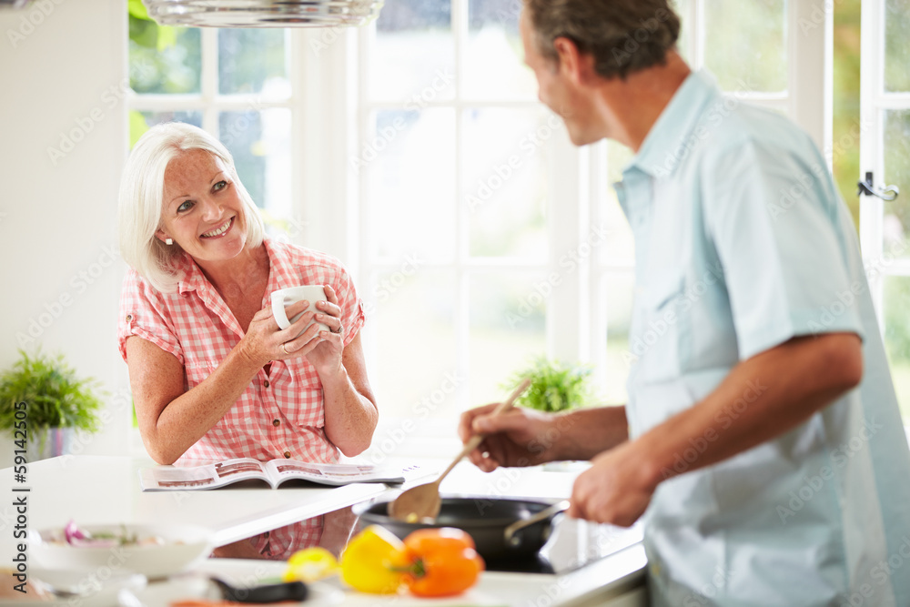 Middle Aged Couple Cooking Meal In Kitchen Together Middle Aged Couple Cooking Meal In Kitchen Together