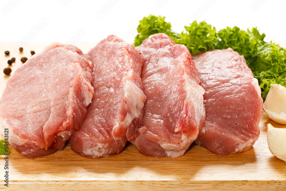 Raw pork on cutting board and vegetables Raw pork on cutting board and vegetables