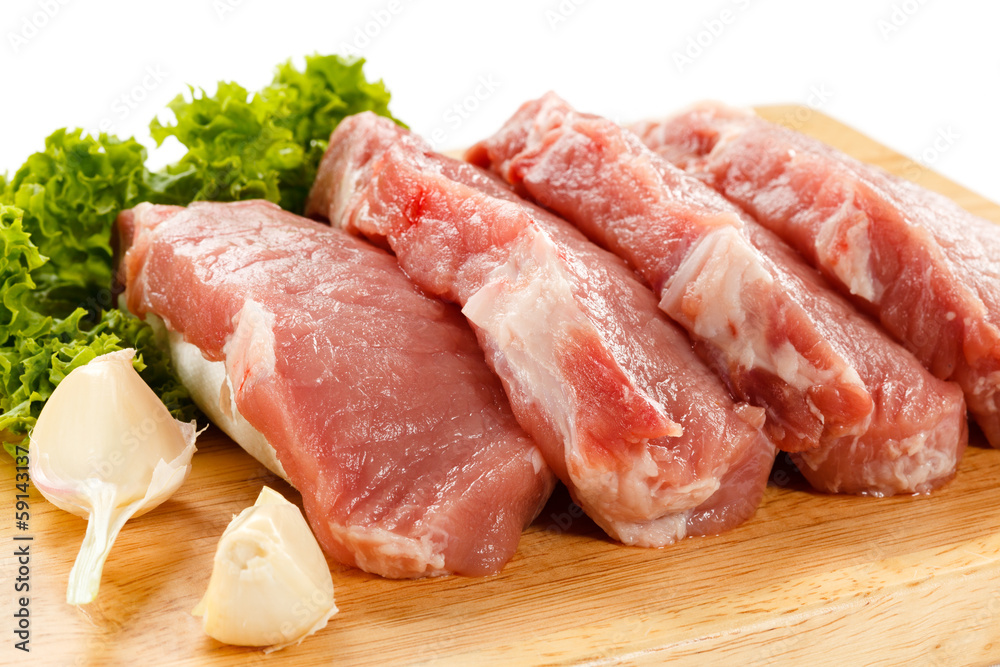 Raw pork on cutting board and vegetables Raw pork on cutting board and vegetables