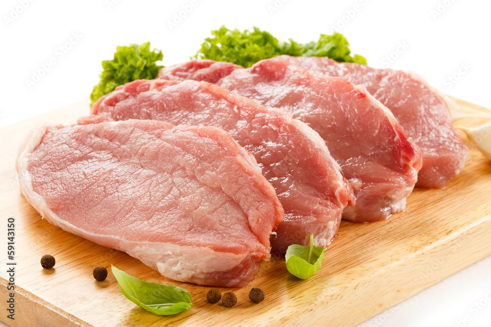 Raw pork on cutting board and vegetables Raw pork on cutting board and vegetables